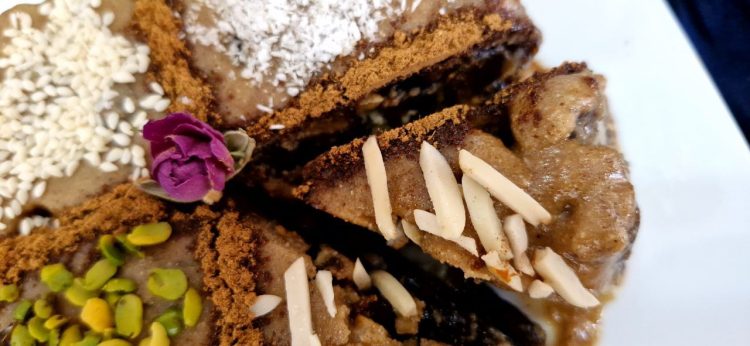 Sliced Persian Ranginak dessert filled with dates and walnuts