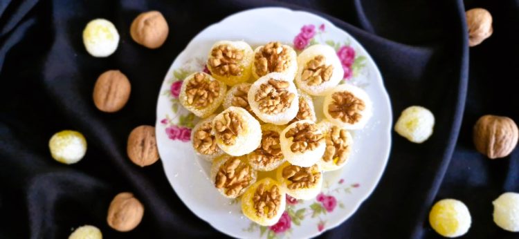 Homemade Persian baslogh coated in coconut flakes and topped with walnuts